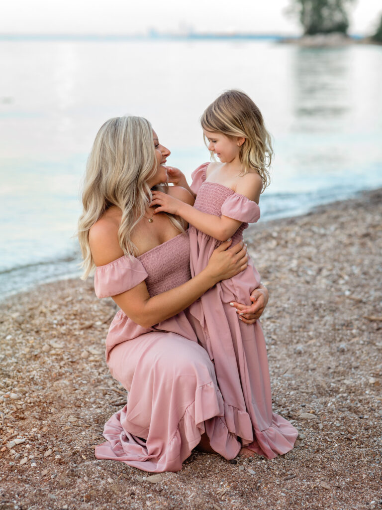 mom and daughter embracing on the beach for family photos Huntington Beach Bay Village