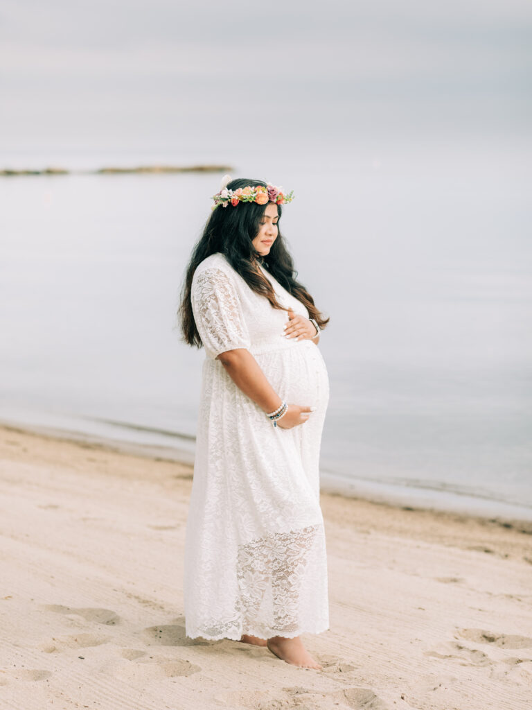 pregnant mother holding belly for maternity photoshoot Huntington beach bay village