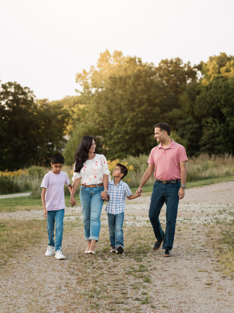 mom, dad and two sons walking holding hands at park for family photos Westcreek Reservation