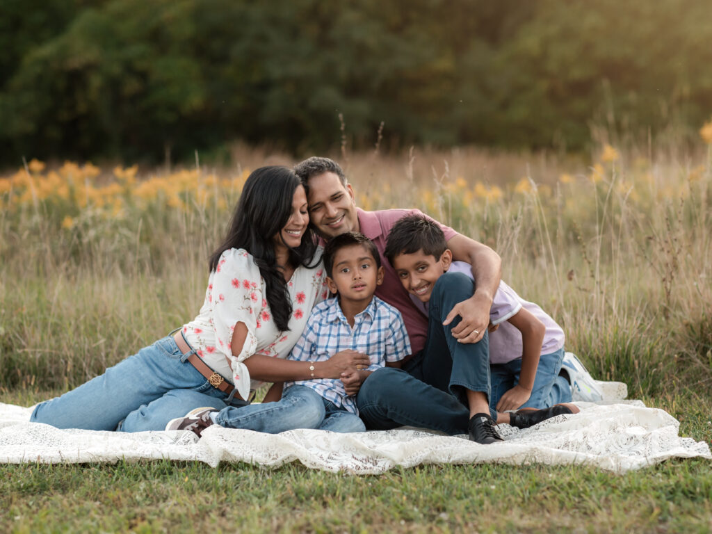 mom, dad and two sons sitting on lace blanket for family photos Westcreek Reservation