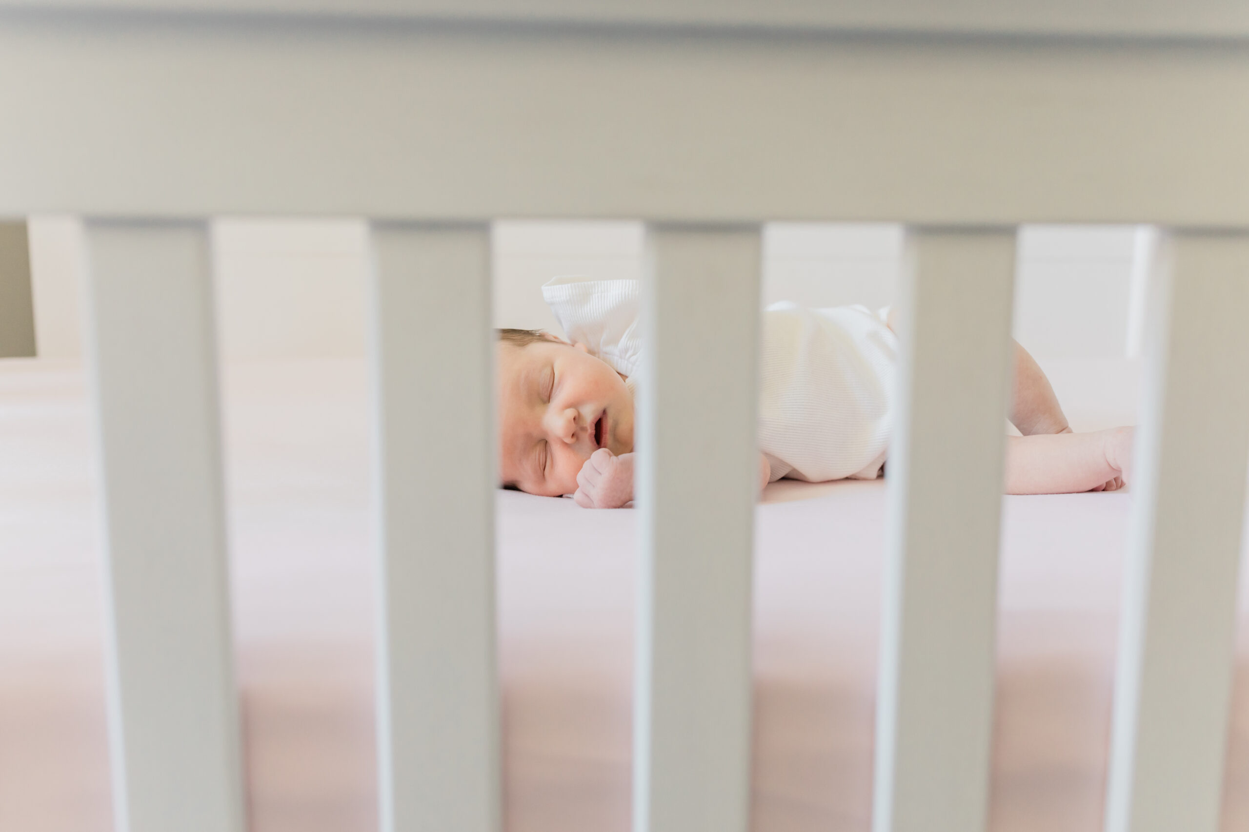 newborn baby girl sleeping in crib