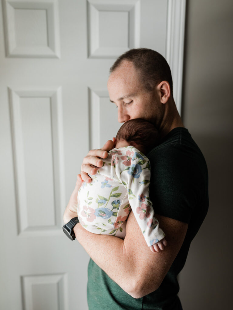 dad holding newborn baby in his arms