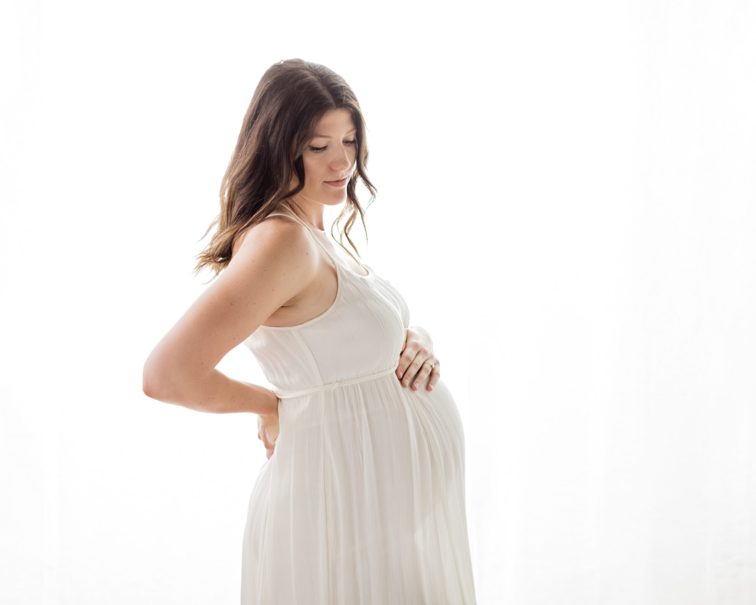 mom in white boho dress holding pregnant belly for photoshoot prenatal yoga cleveland