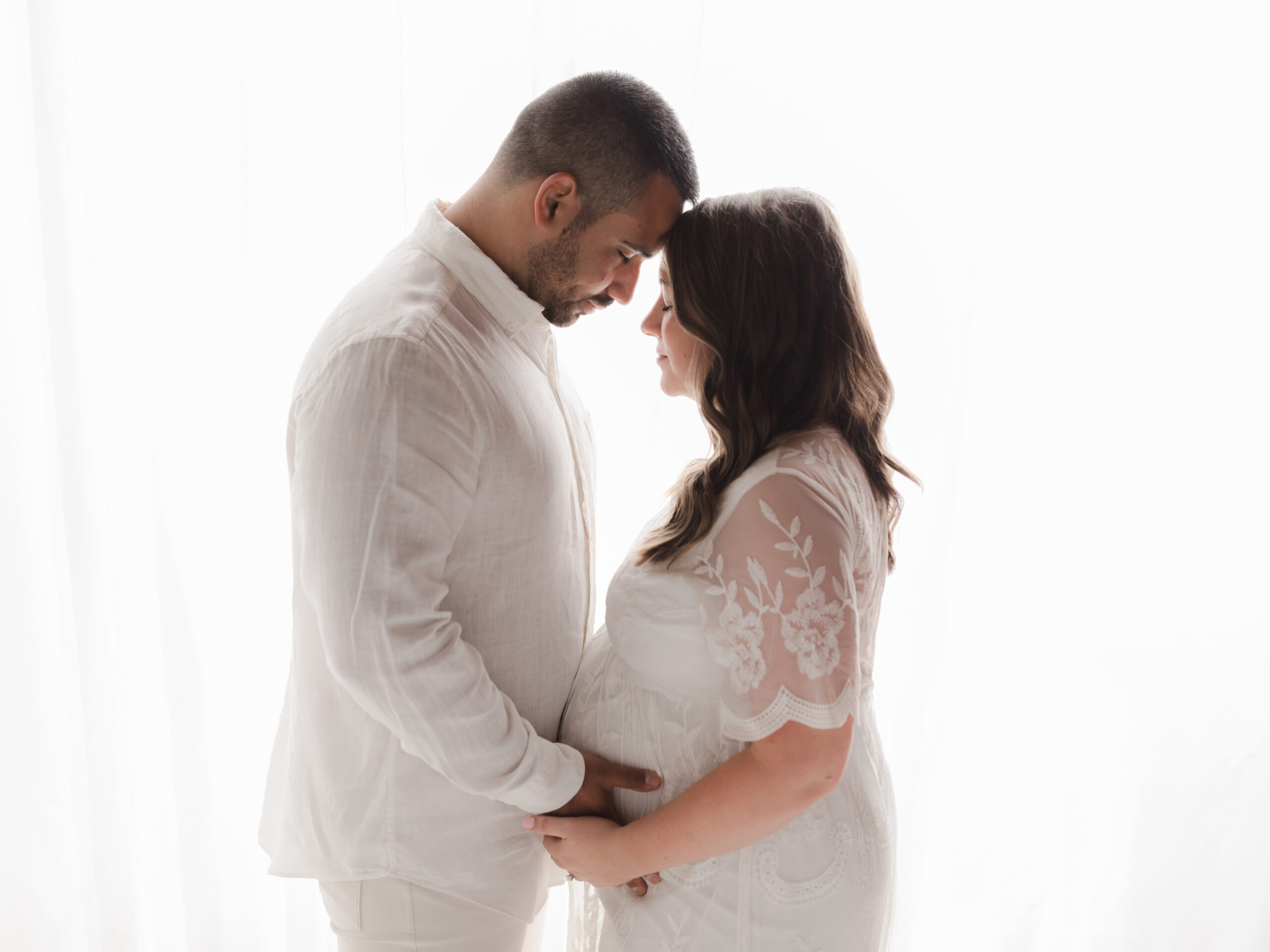 husband and wife holding pregnant belly for studio maternity portraits The spa at Yellow Creek