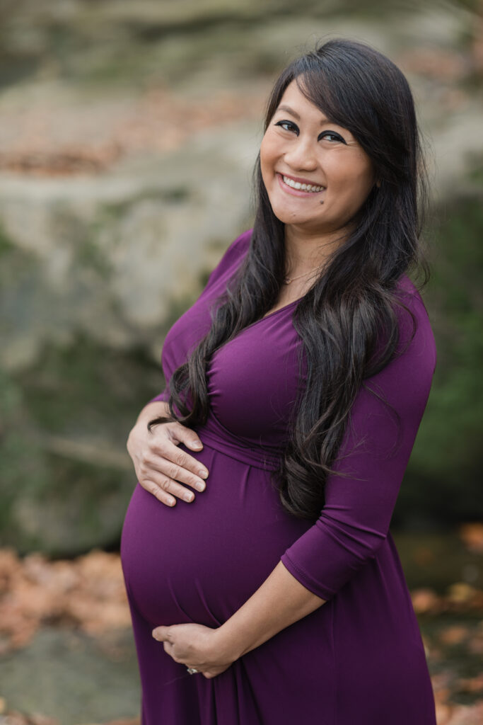 mom holding pregnant belly for photos The Womb Wellness Center | Supportive Service During Pregnancy