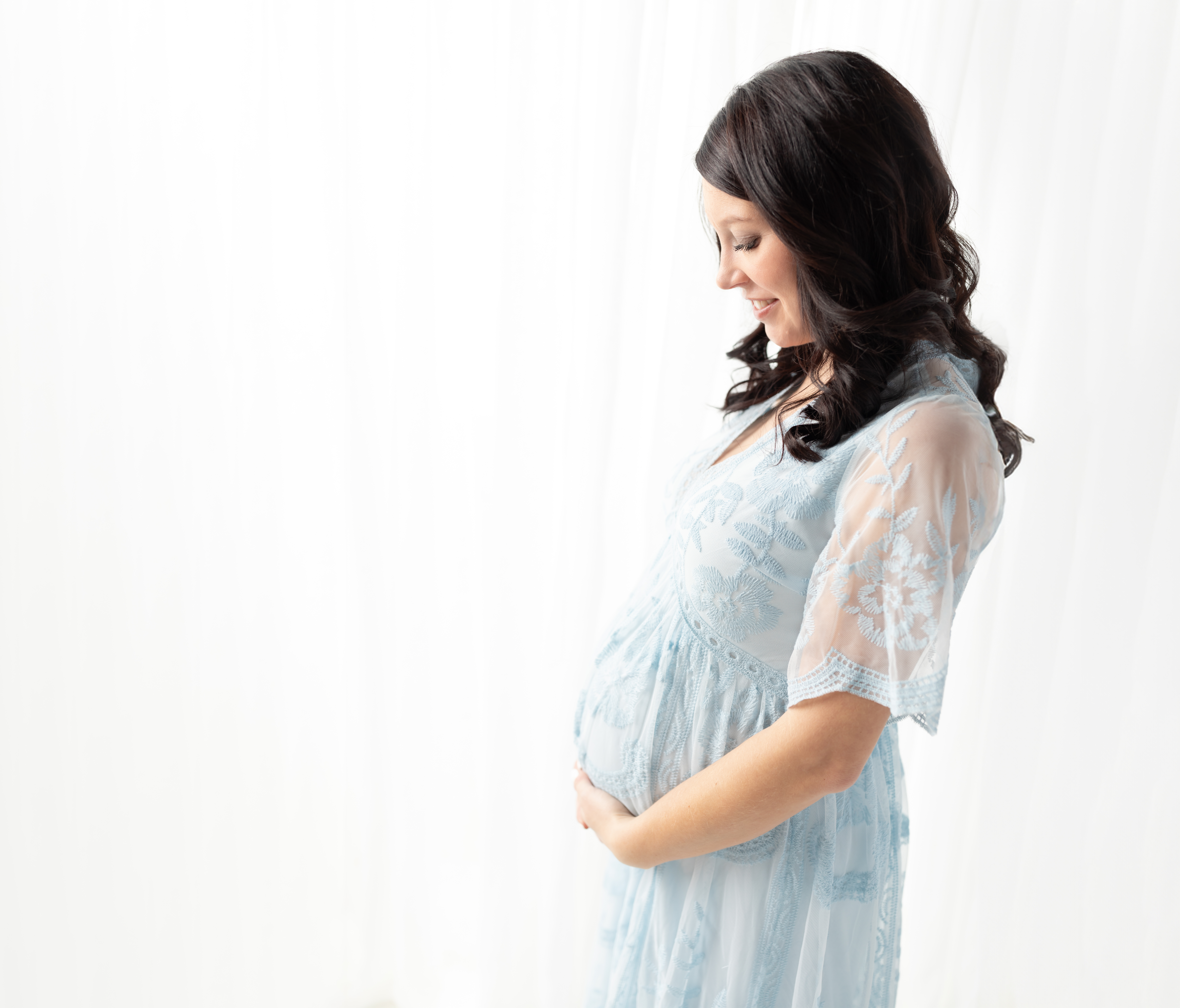 pregnant mother in blue lace dress holding baby bump for maternity photoshoot prenatal yoga cleveland