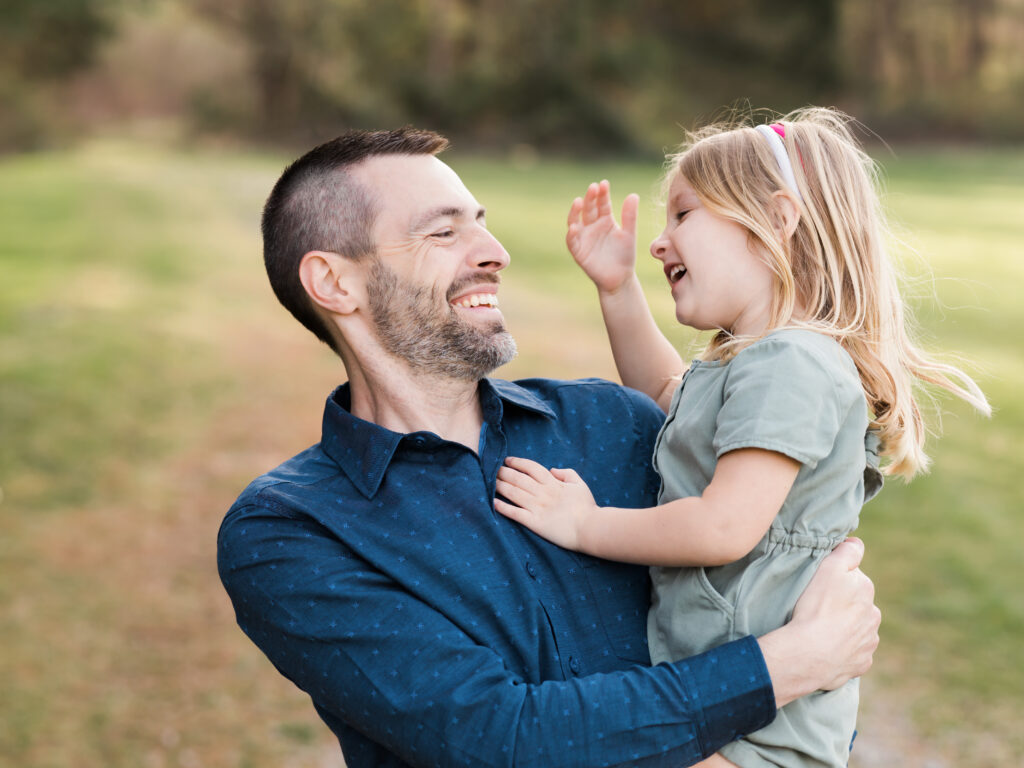 dad and daughter laughing for family photos