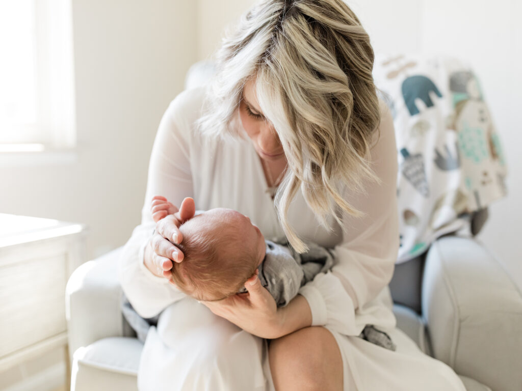 mom holding newborn baby girl in nursery