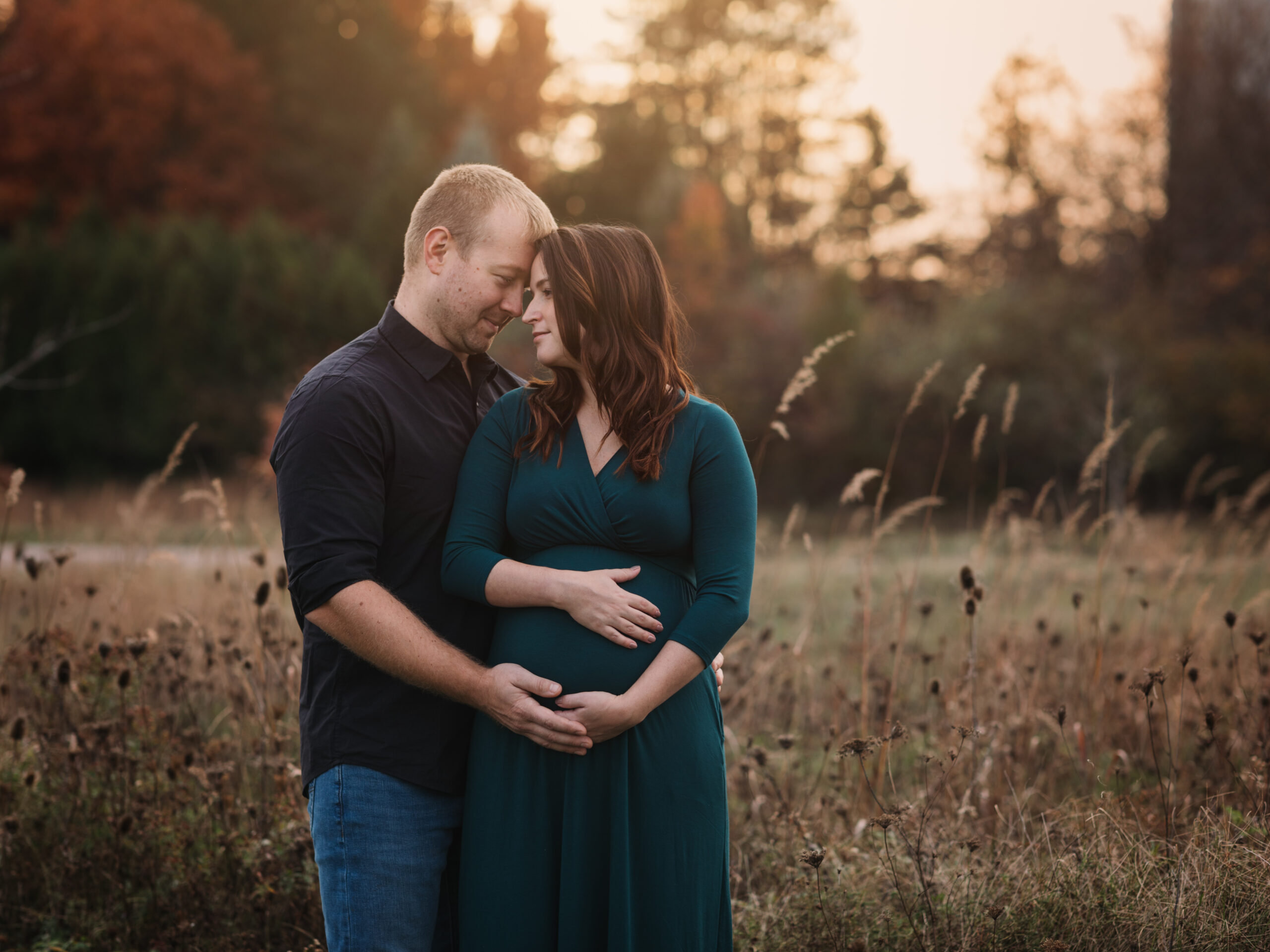 husband and wife holding pregnant belly for maternity photoshoot Carolyn Ludwig Mugrage Park