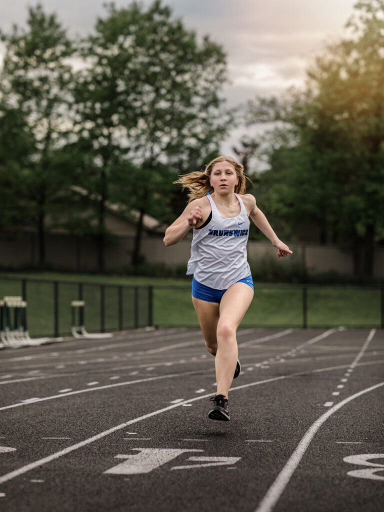 Girl running on Taliak track for senior portraits