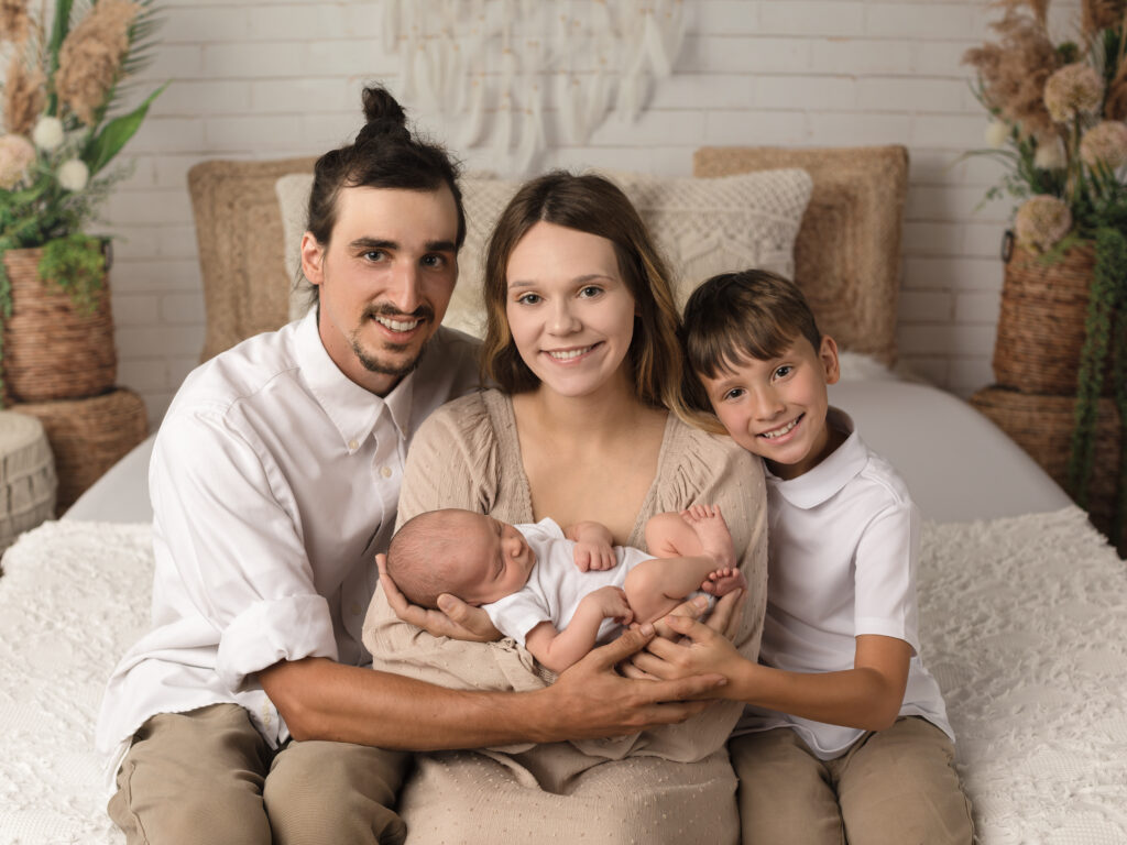 family holding newborn baby boy for family portrait