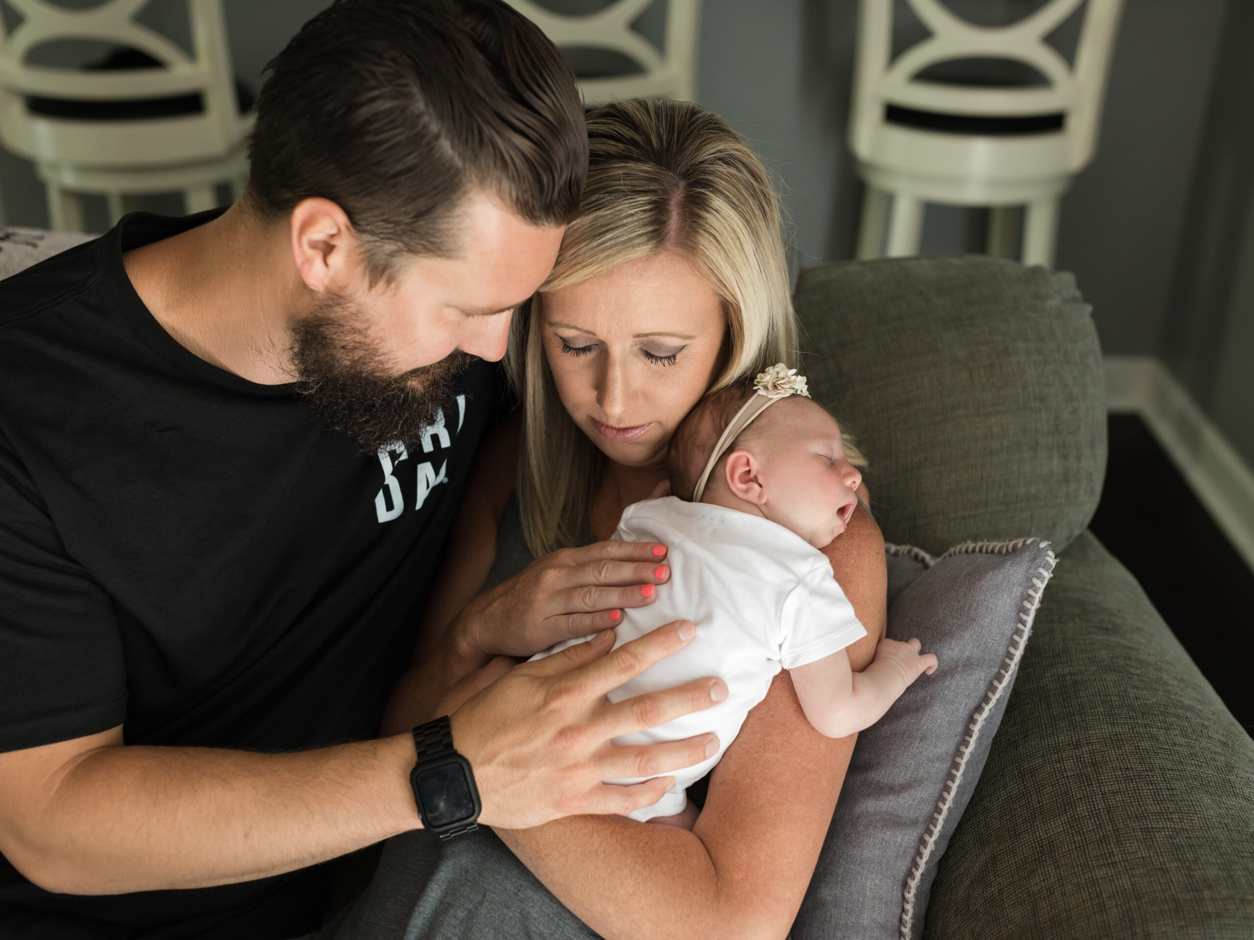 mom and dad holding newborn baby girl for in home lifestyle newborn photography