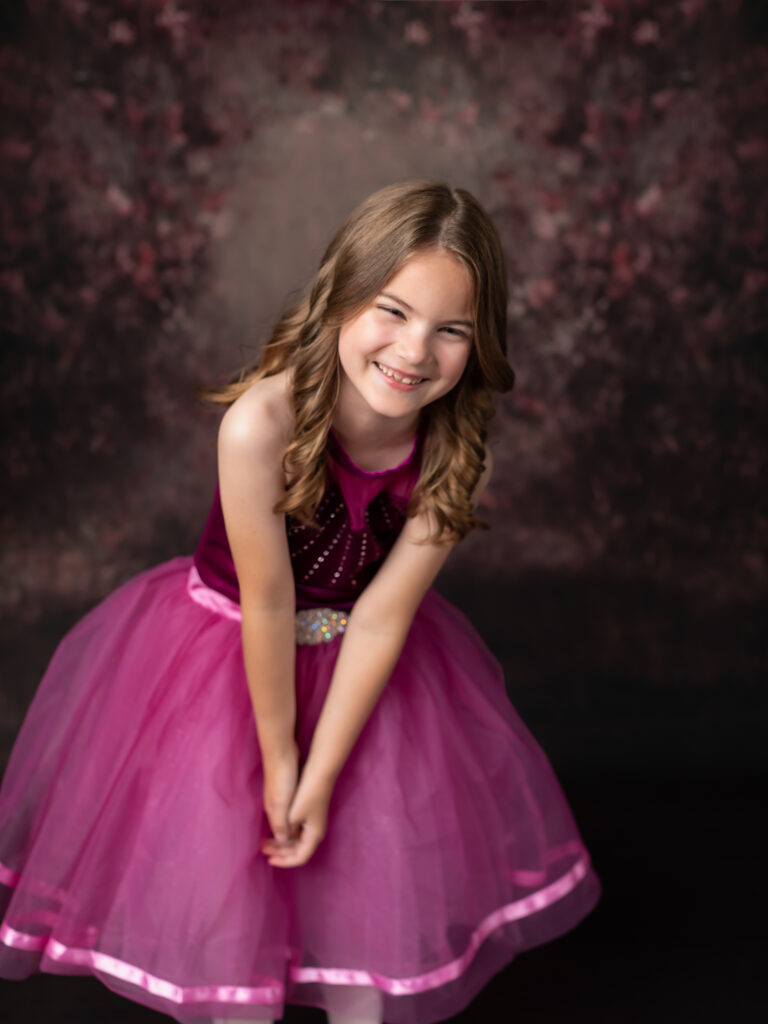 girl in pink dance costume laughing for studio portraits