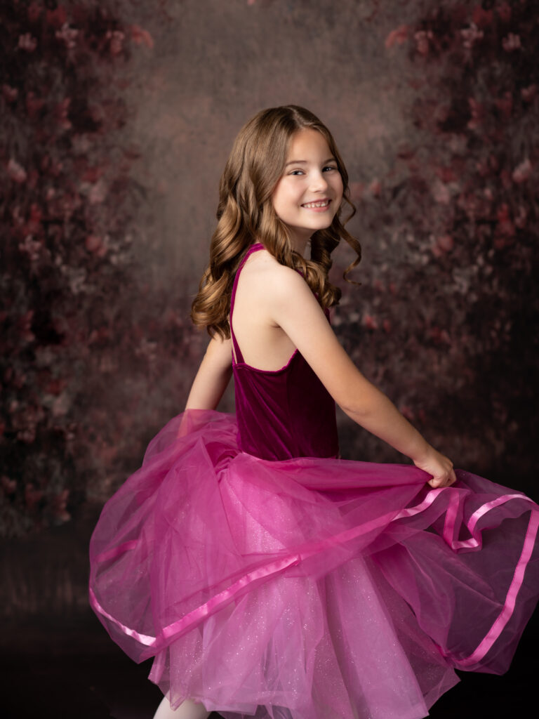 girl in pink dance costume dancing for studio portraits