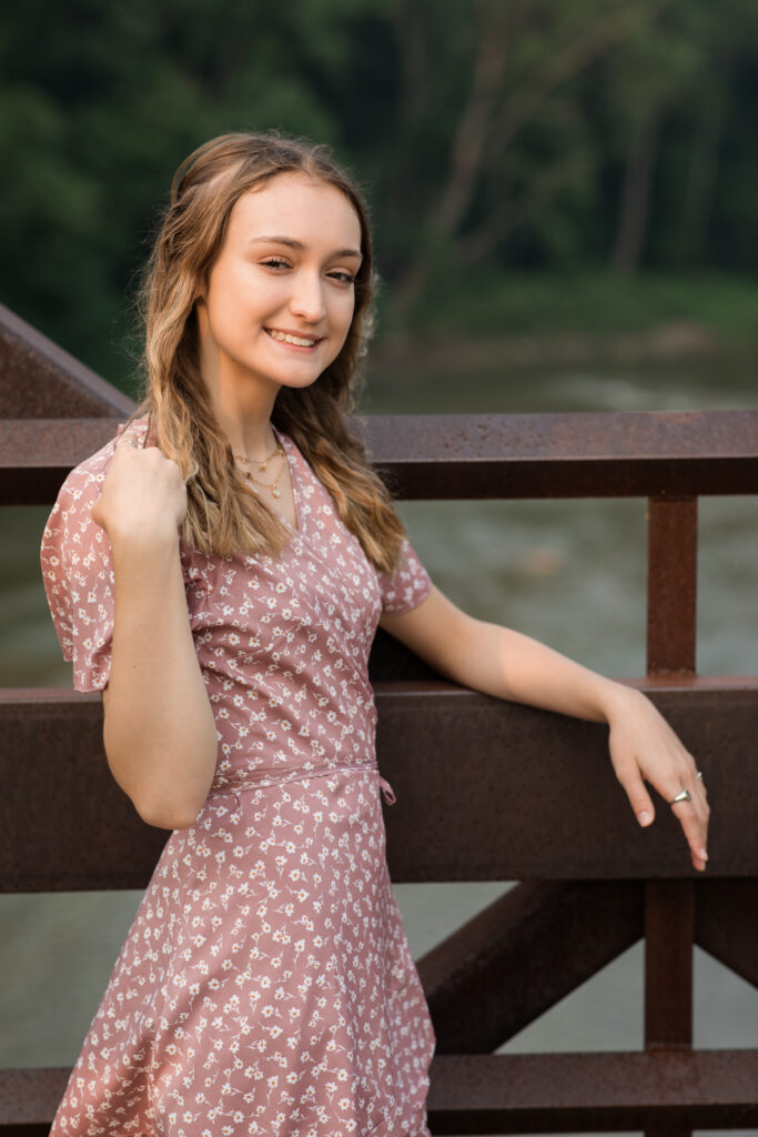 senior girl posing on bridge for senior portraits