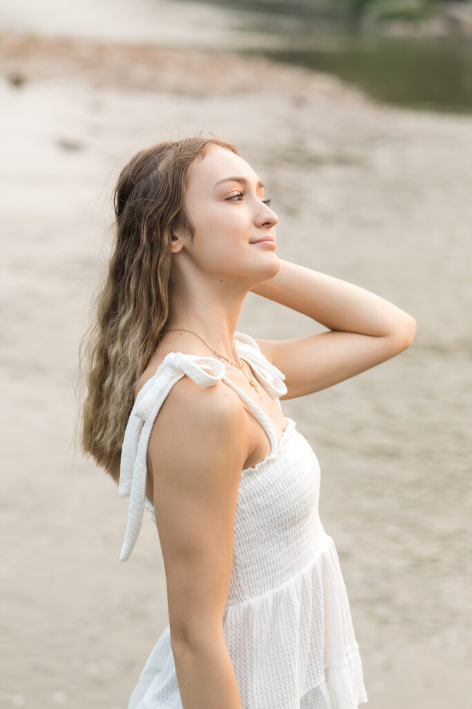 girl posing by creek for senior photos