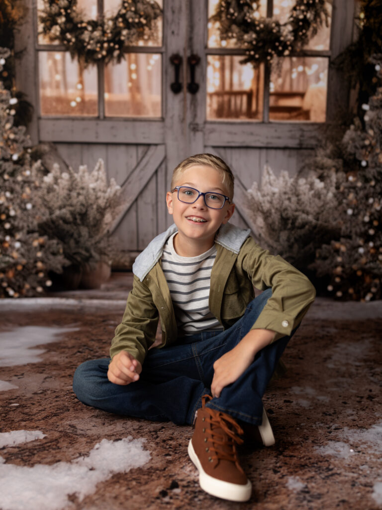 boy in green hoodie sitting for Christmas portraits 