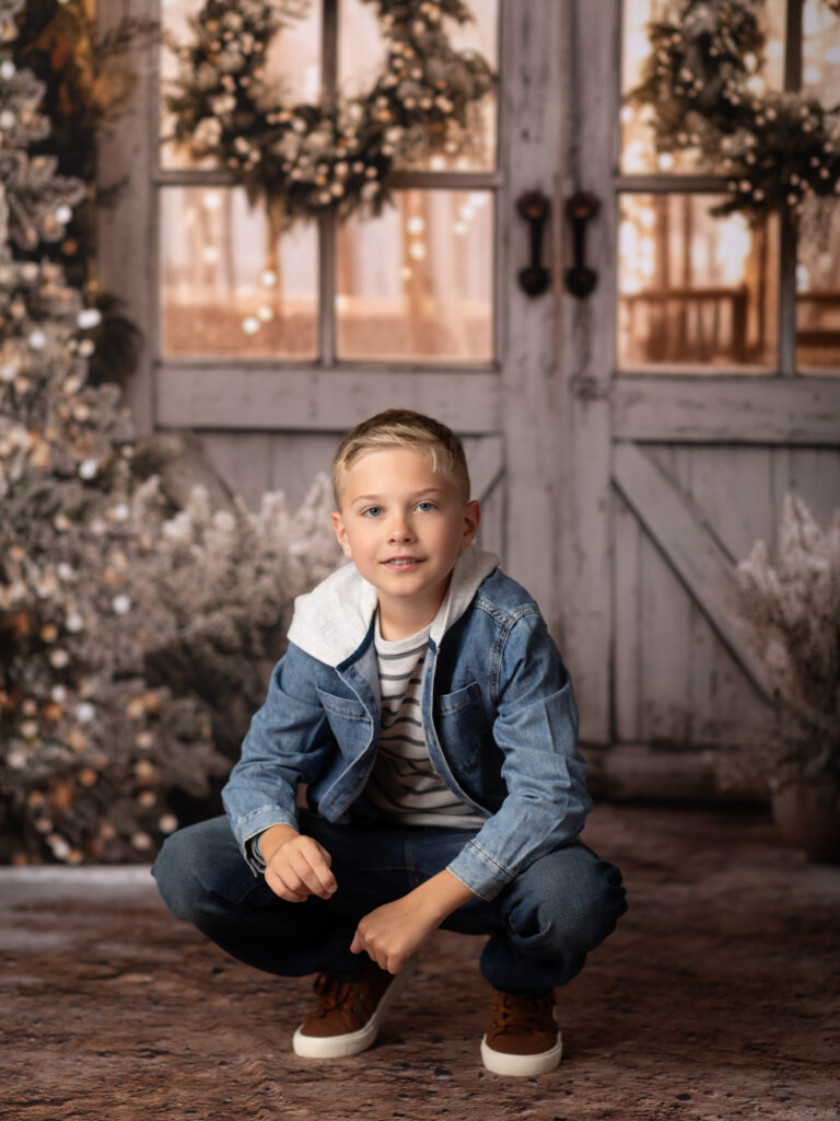 boy in jean jacket sitting for christmas portraits Christmas photography sessions in Cleveland