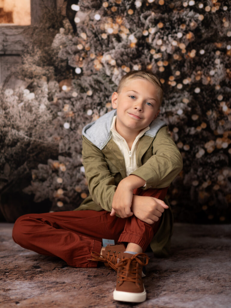 boy in green hoodie sitting for Christmas portraits 