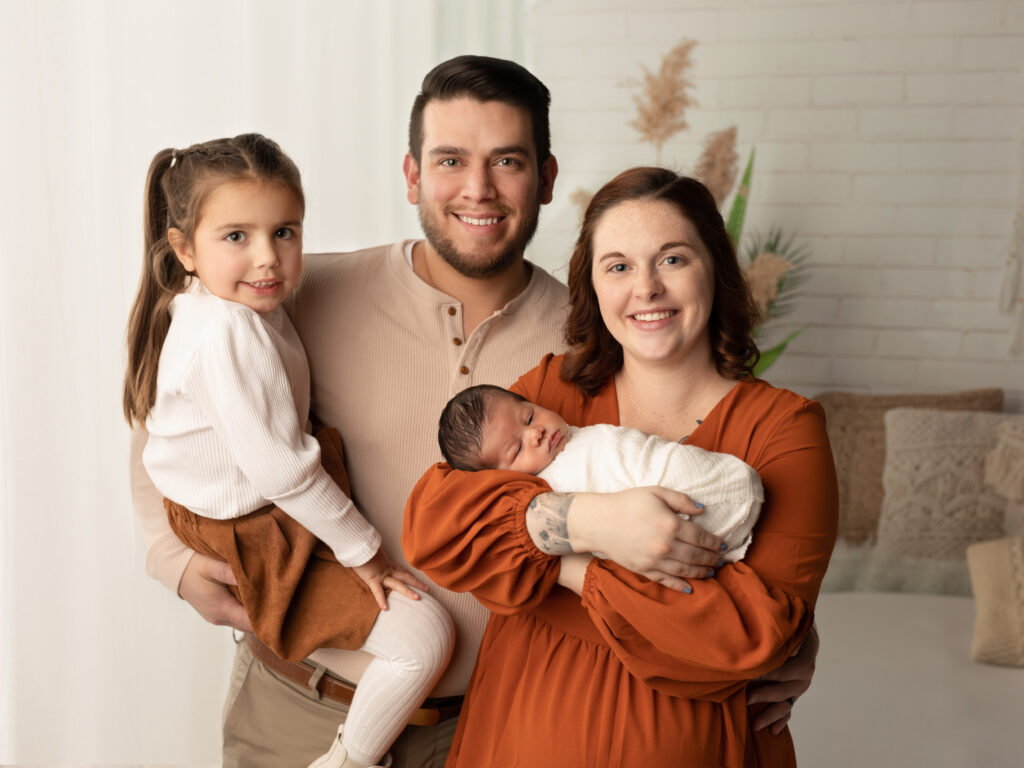 family holding newborn baby boy for studio portraits