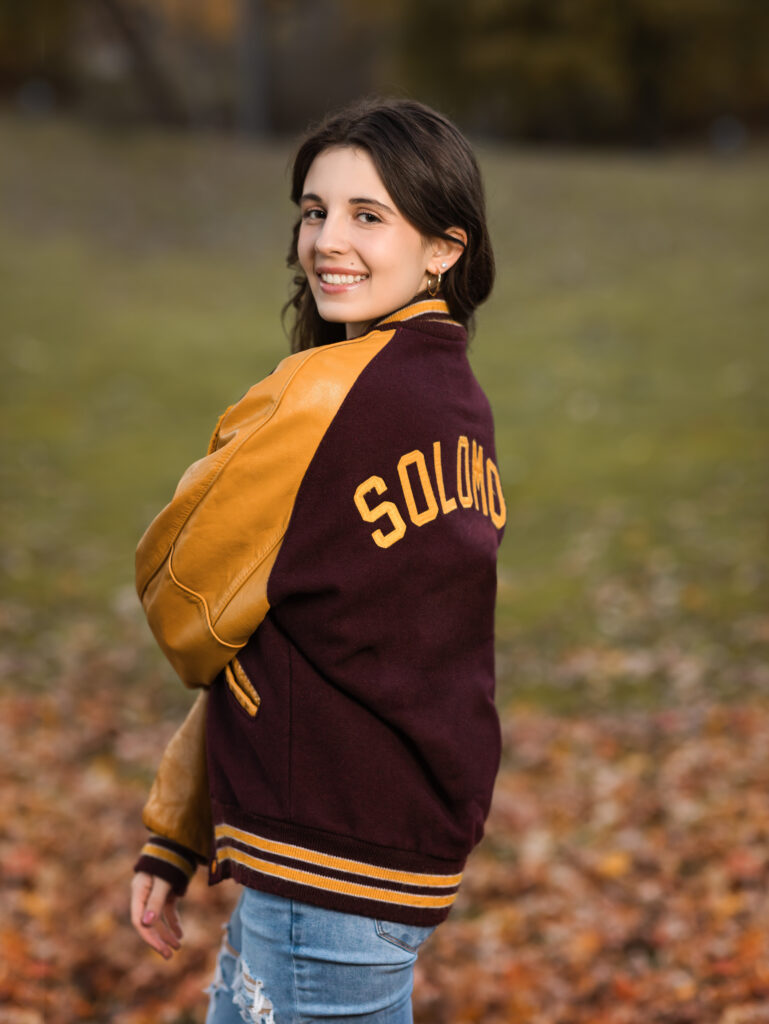 senior posing with letterman jacket for portraits