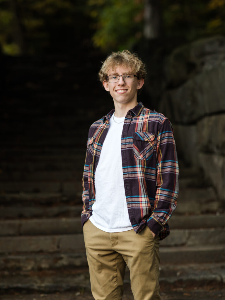 male senior standing on stairs for portraits