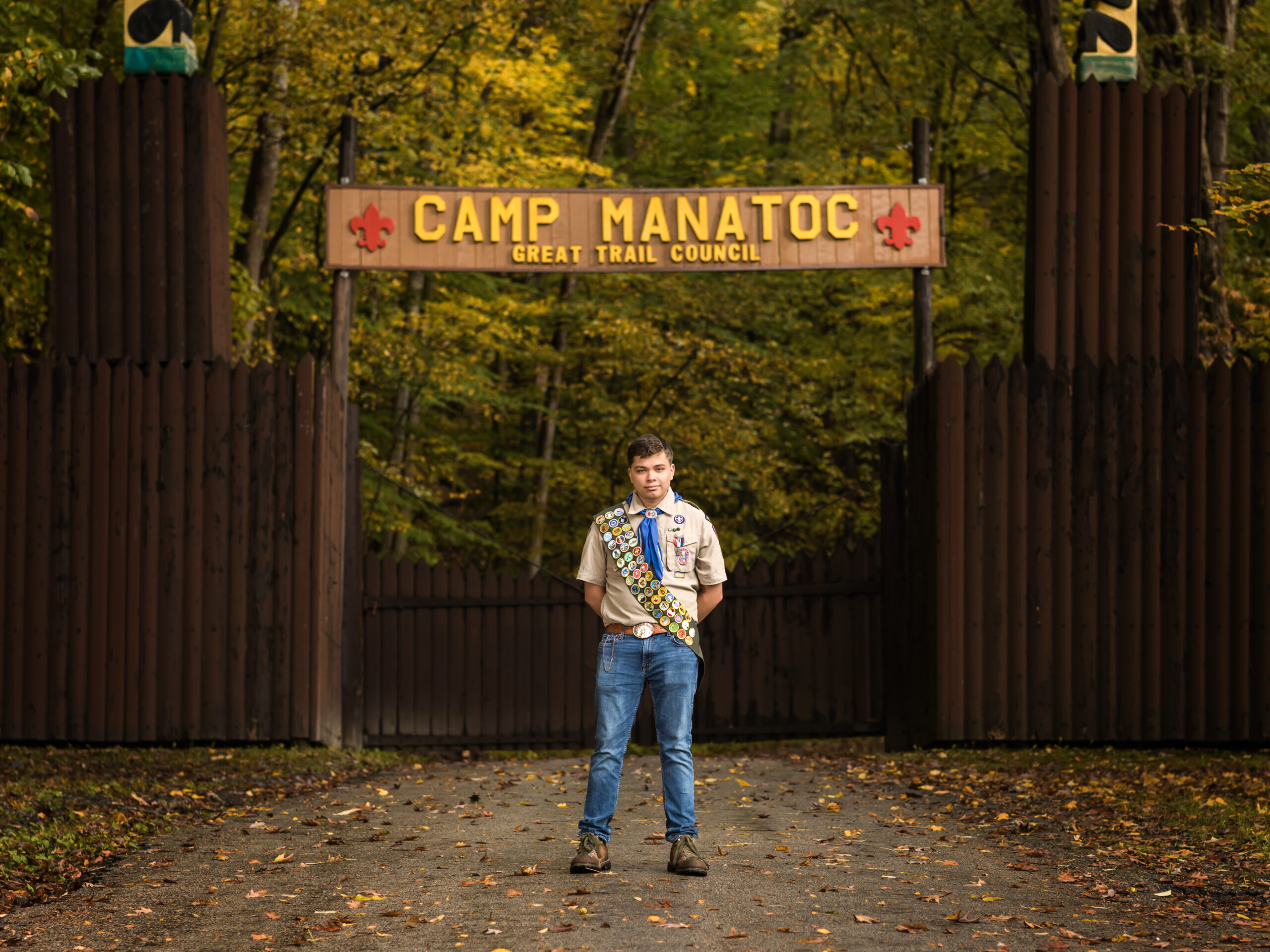 senior boy with boyscout uniform on standing at camp manatoc entrance