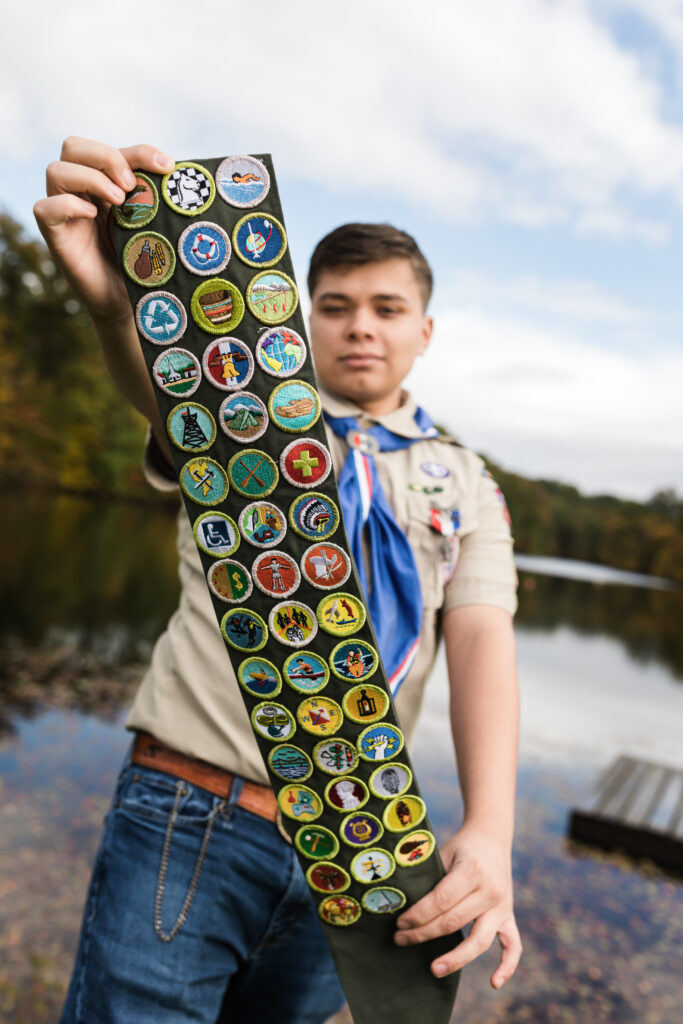 boy scout holding badges for senior photos camp manatoc