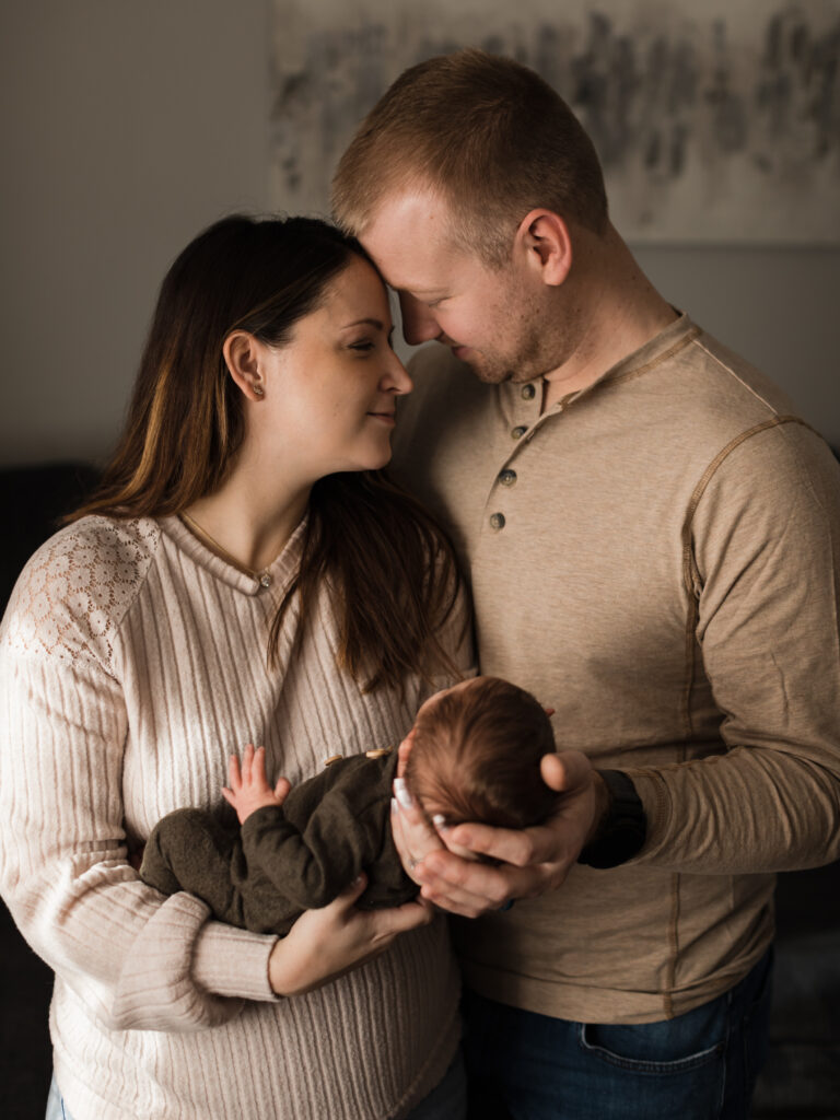 mom and dad holding newborn baby boy for in home session Southwest General Medical Group