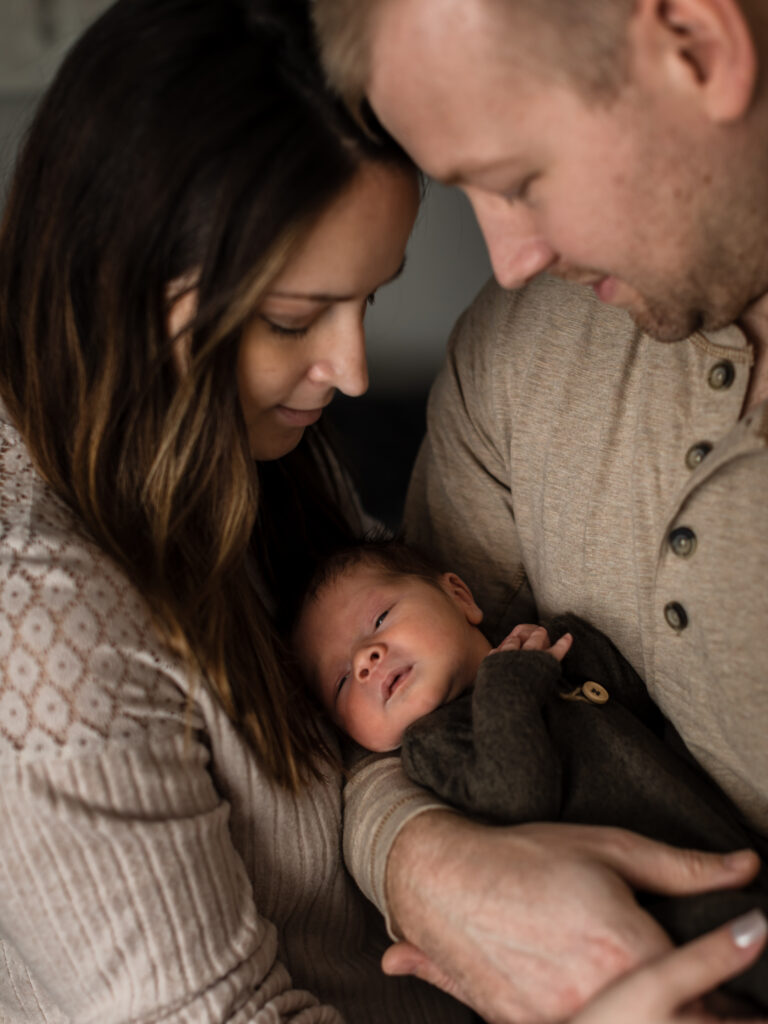 mom and dad holding newborn baby boy for in home session Southwest General Medical Group