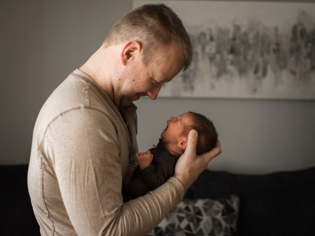 dad holding newborn son for in home lifestyle newborn session