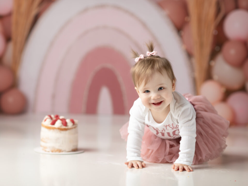 one year old girl sitting with cake for cake smash photoshoot 