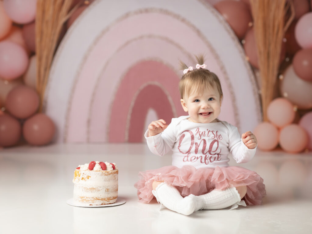 one year old girl sitting with cake for cake smash photoshoot akron ohio photographer