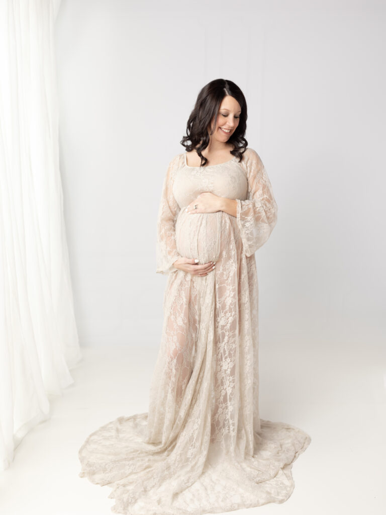 pregnant mother in lace dress holding belly for maternity photoshoot Shaker Womens Wellness