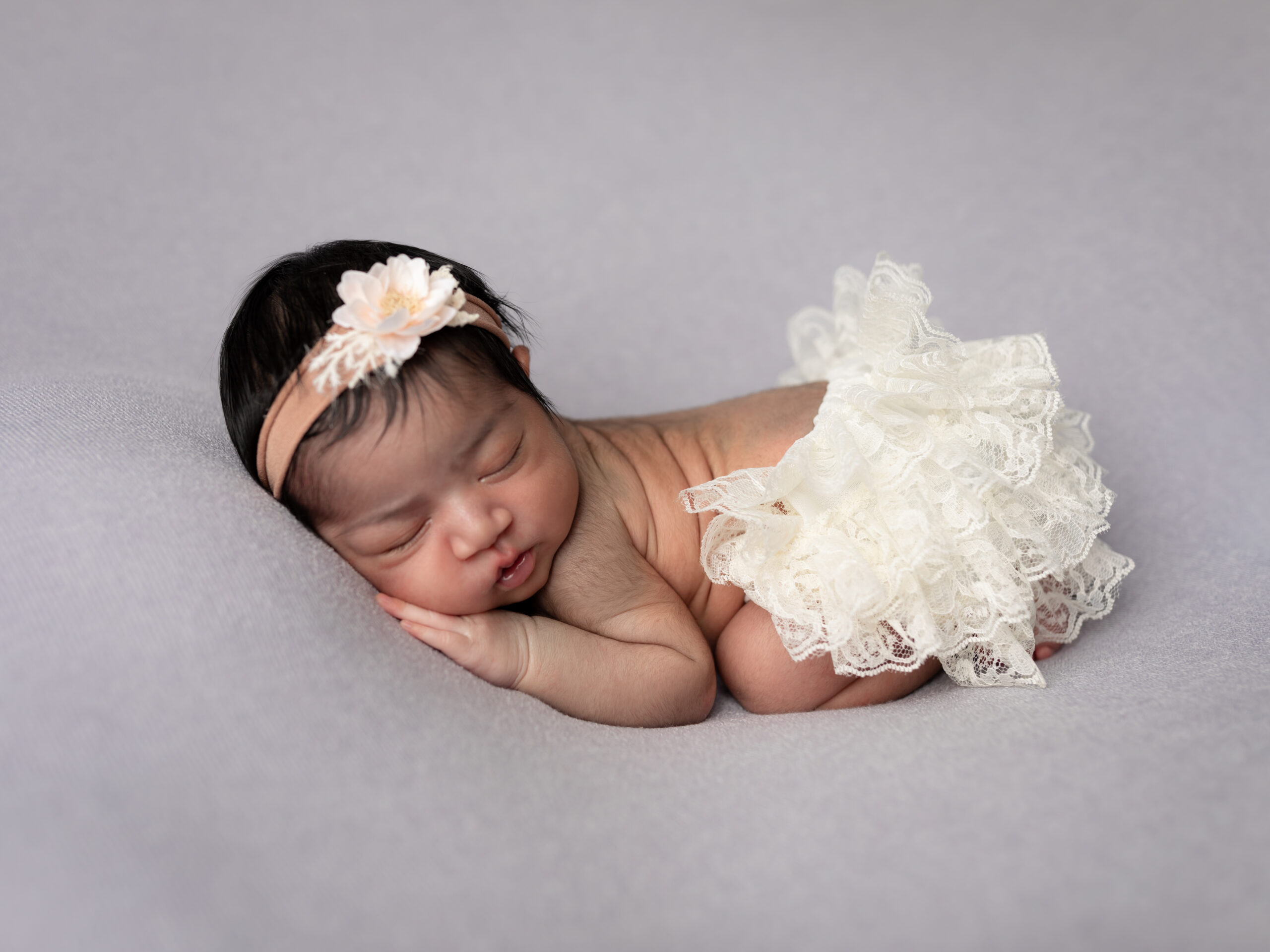 newborn baby girl in white tutu posed on purple fabric Baby shower venues Cleveland