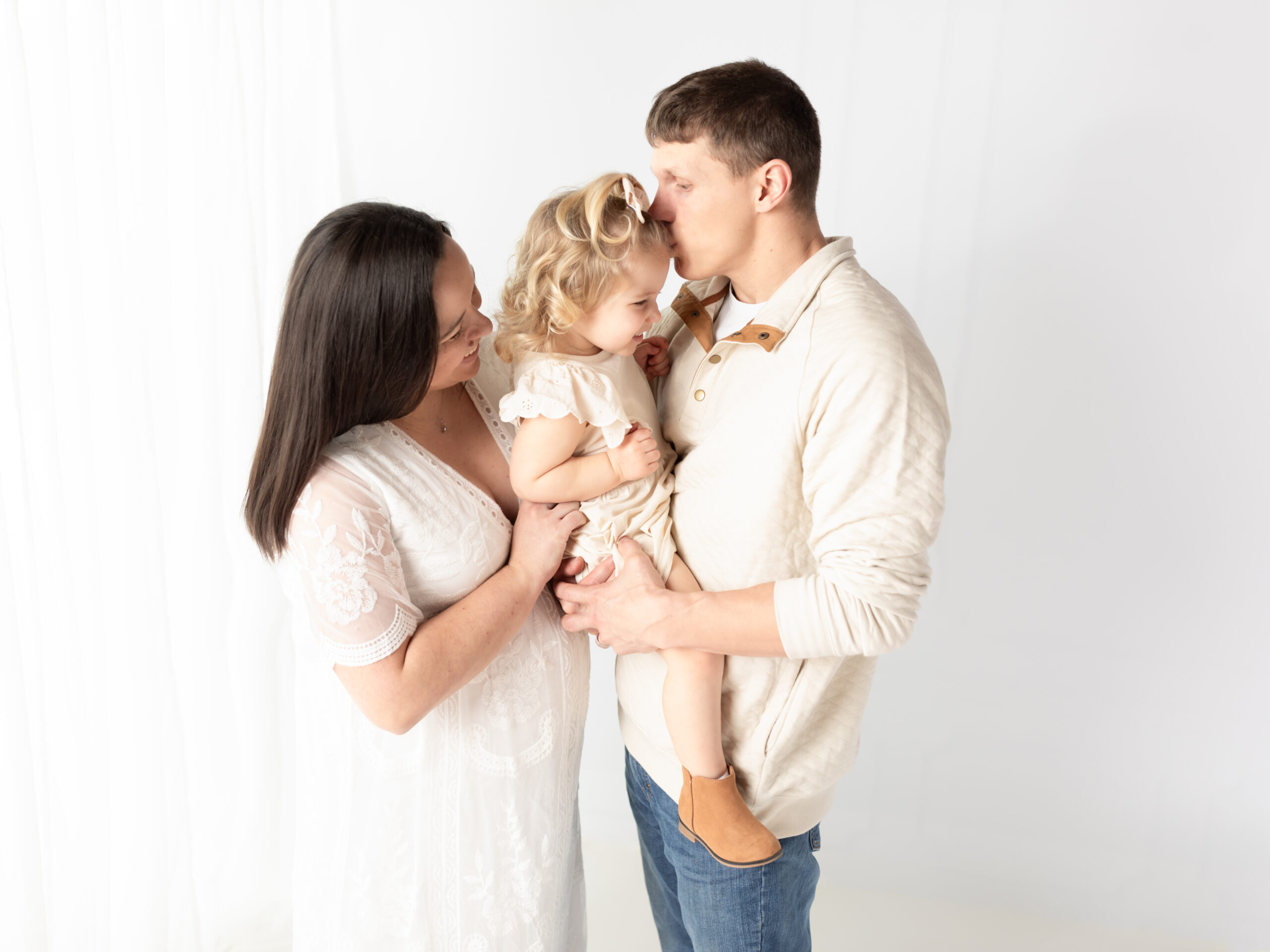 mother and father holding two year old daughter for maternity photoshoot Essential Escape Strongsville