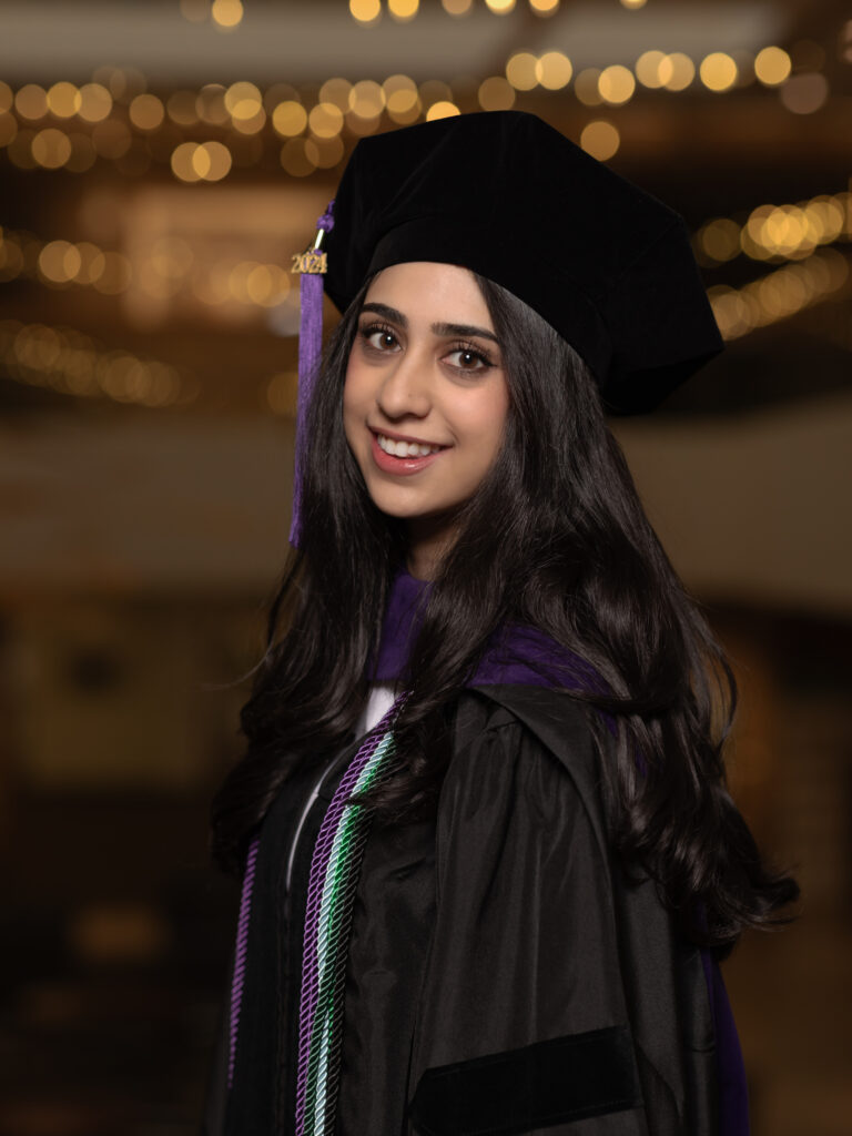 graduate in cap and gown at the atrium of college of law