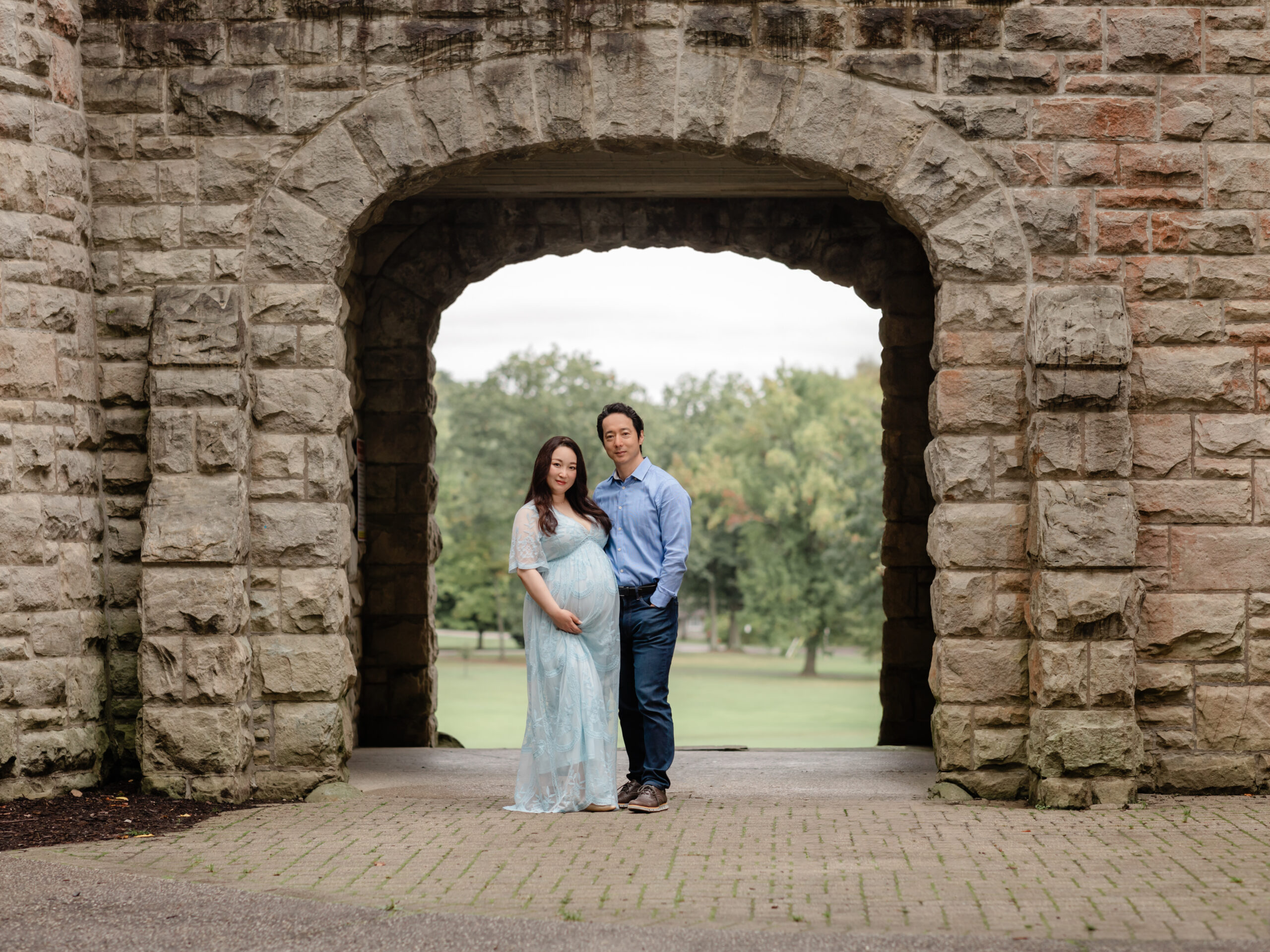 husband and pregnant wife in blue lace dress posed for maternity photos Squires Castle