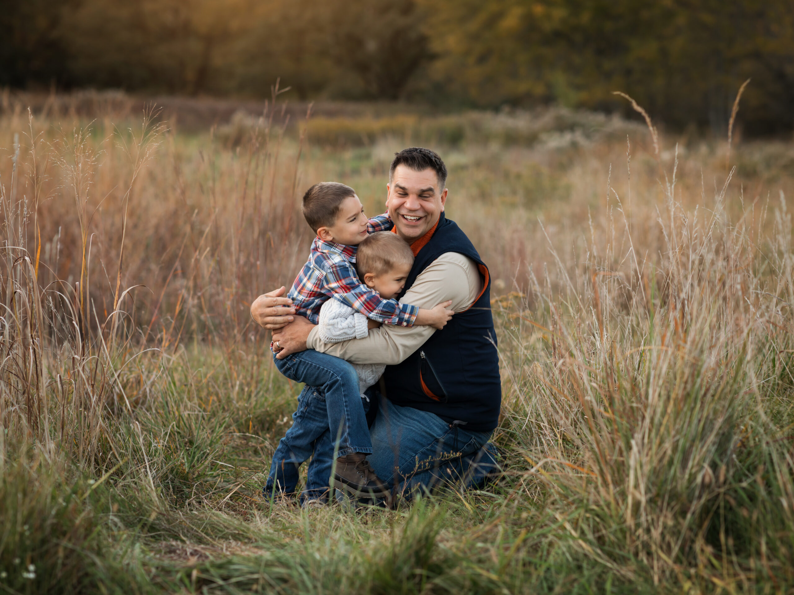 father and two sons hugging in park for family photos Cleveland Toy Stores