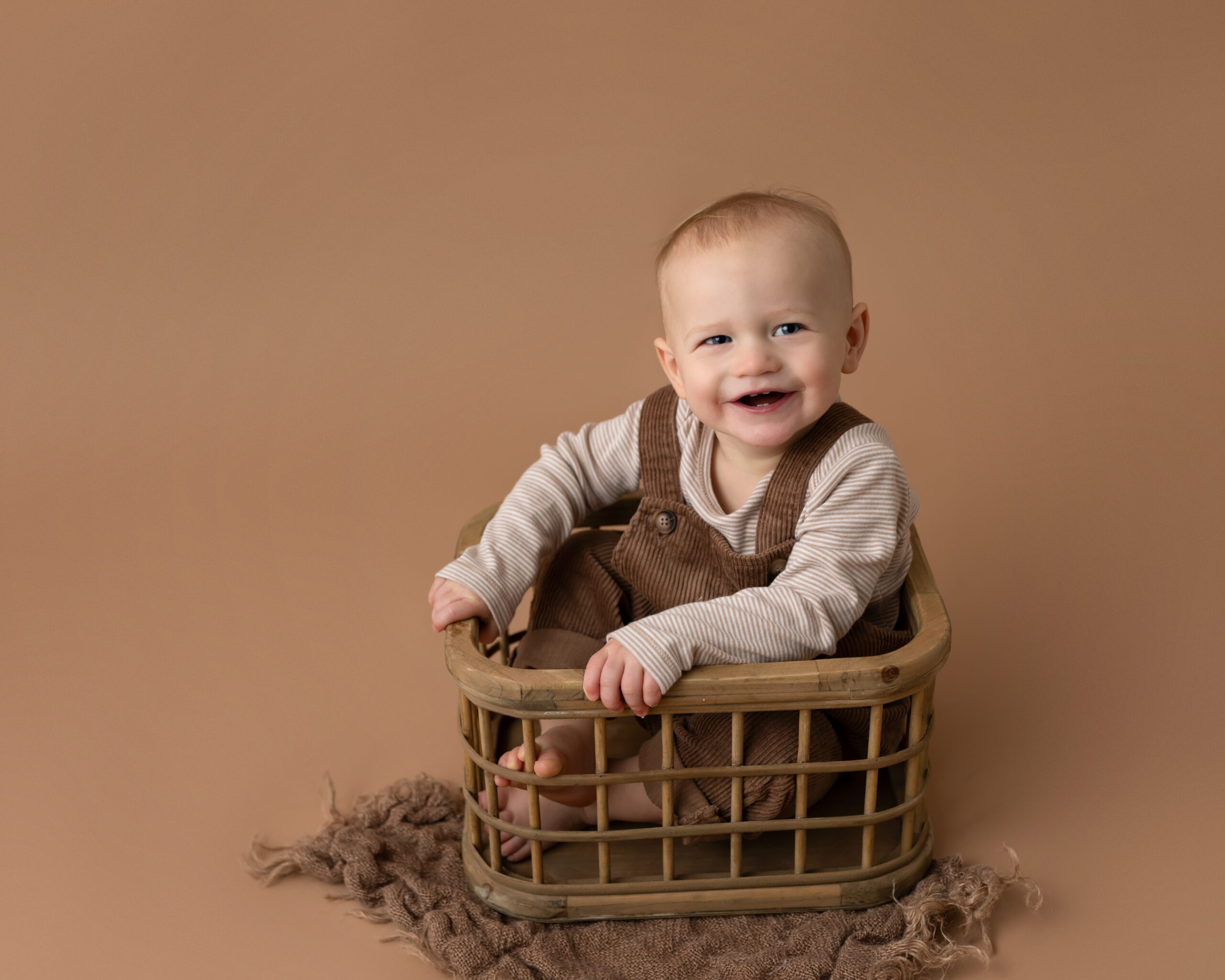 One year old boy sitting in basket with brown backdrop for photoshoot Things To Do In Akron With Kids