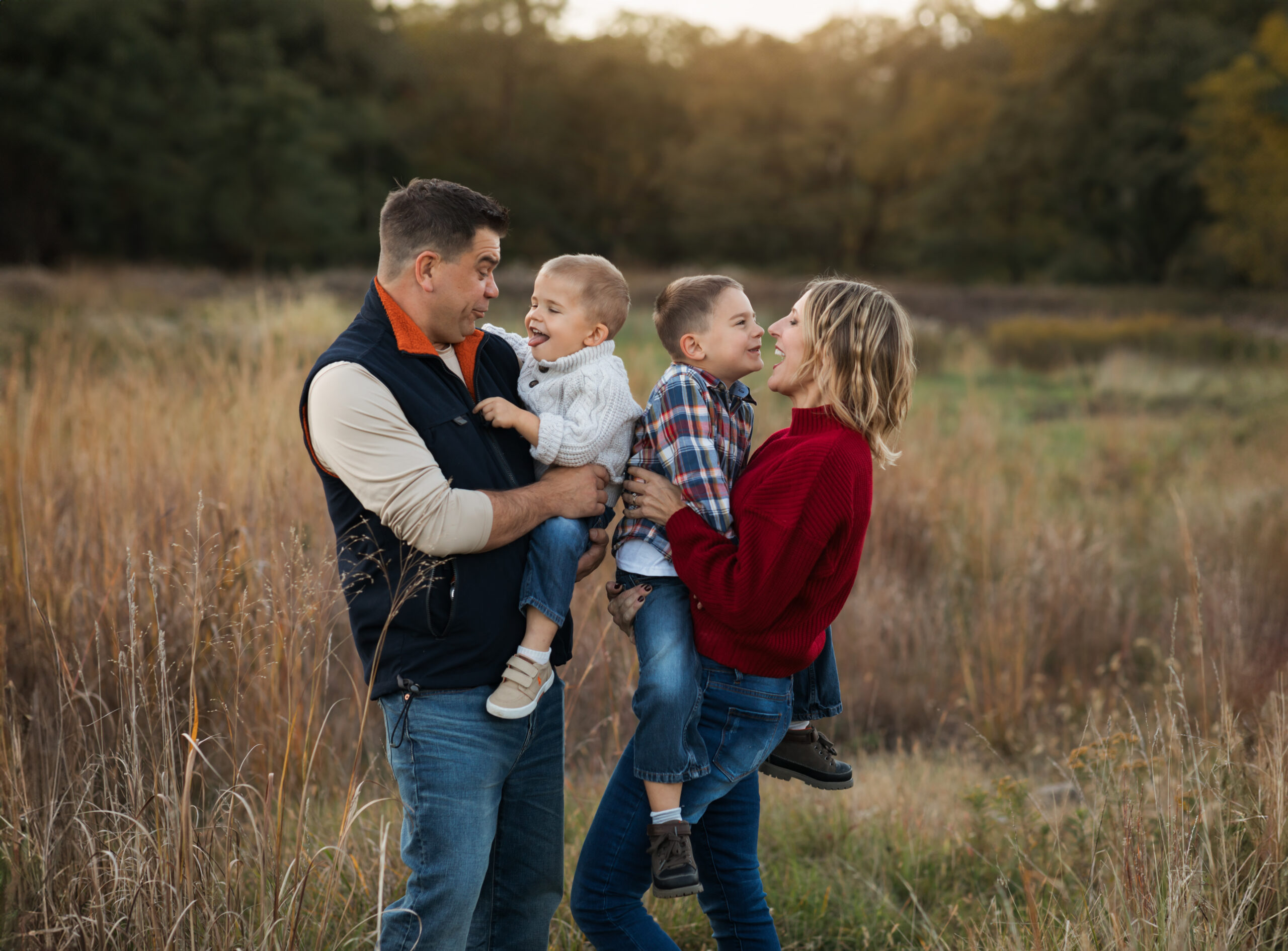 parents holding two sons for fall family photos in park Family Friendly Restaurants in Cleveland