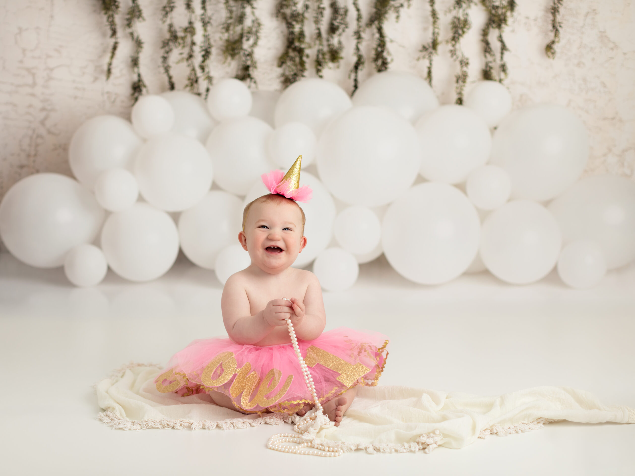 one year old girl in pink tutu sitting for studio birthday photoshoot indoor birthday party places cleveland