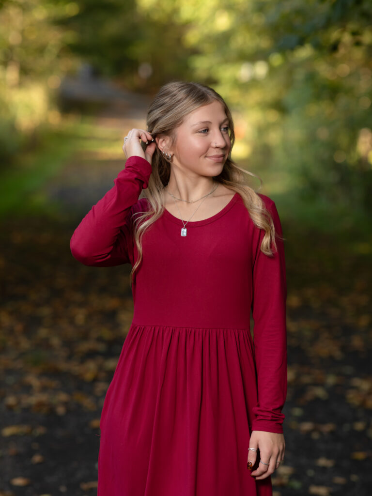 girl in red dress posing in park for fall family photos