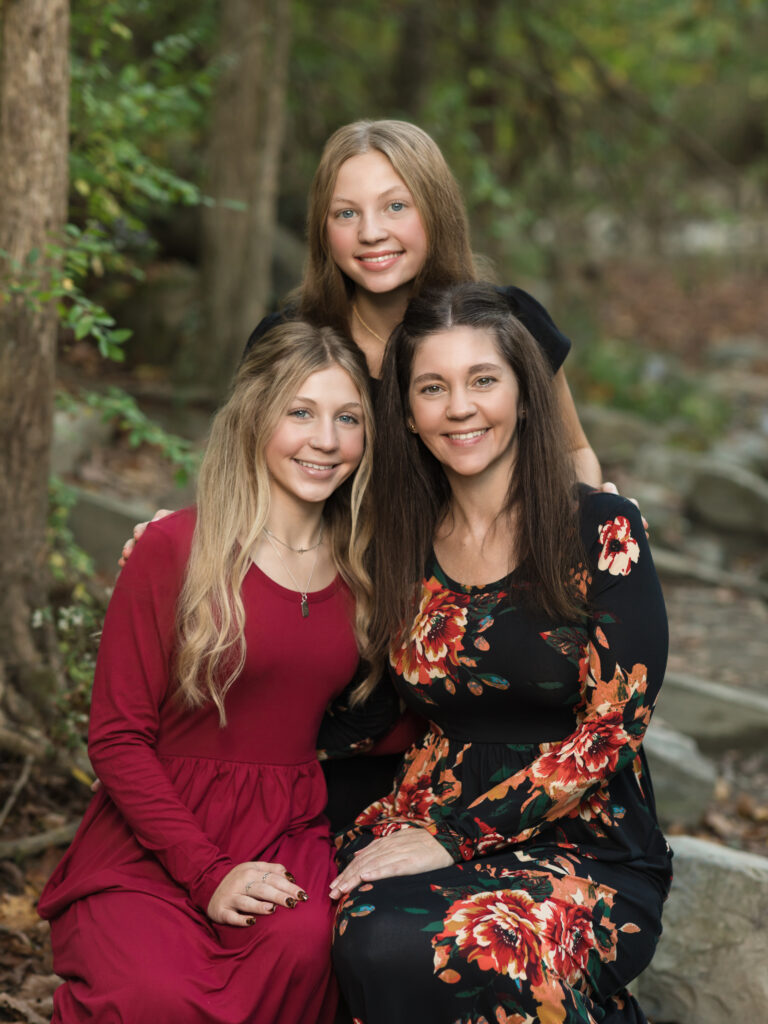 mother and two daughters sitting on rocks for fall family photos Everett Covered Bridge in Peninsula