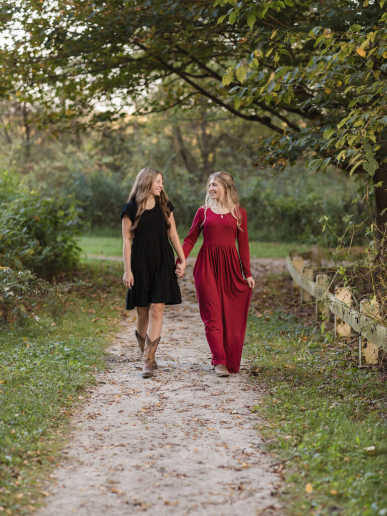 sisters holding hands and walking park for fall family photos