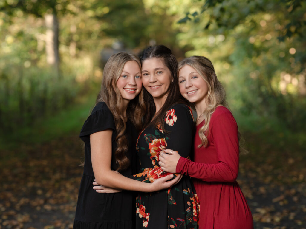 Mother and two daughters hugging for fall family photos Everett Covered Bridge in Peninsula