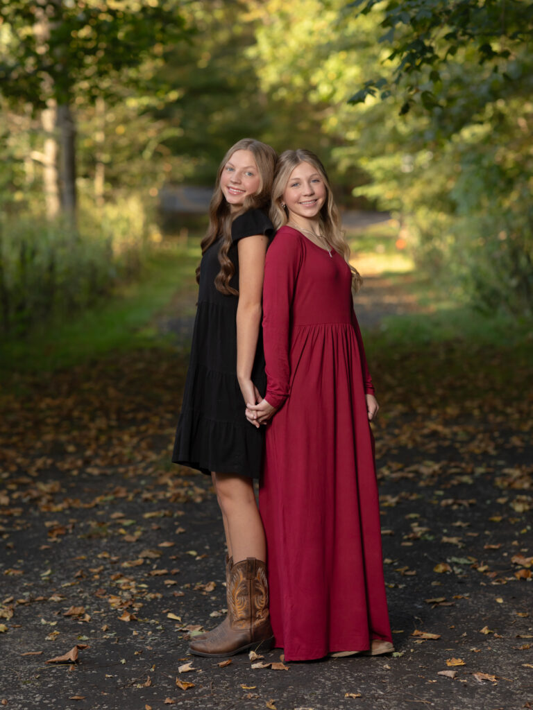 sisters posing for fall family photos in park