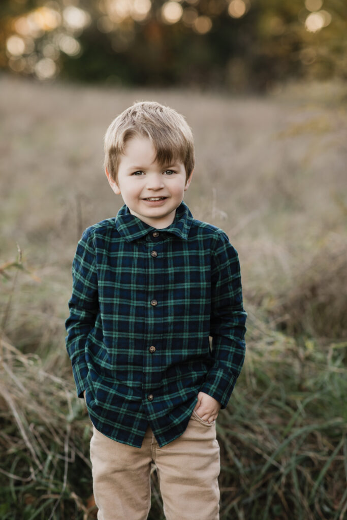 boy in green plaid shirt posing for fall family photos Allardale Park Medina