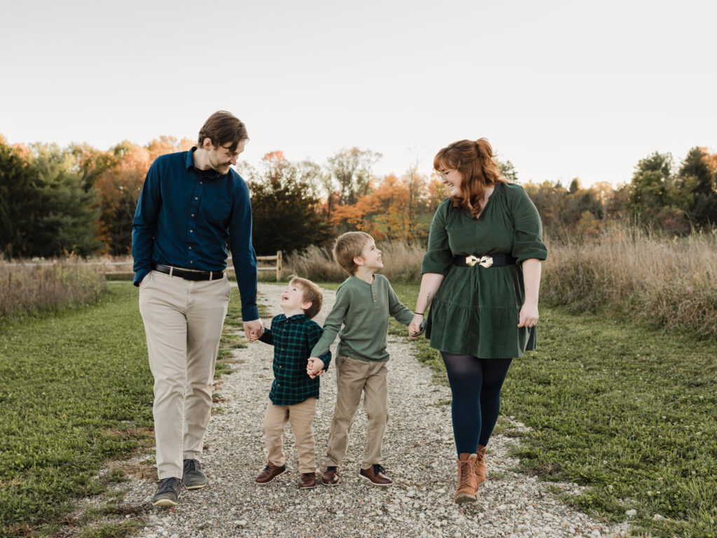parents holding hands with two sons walking in park Allardale Park Medina