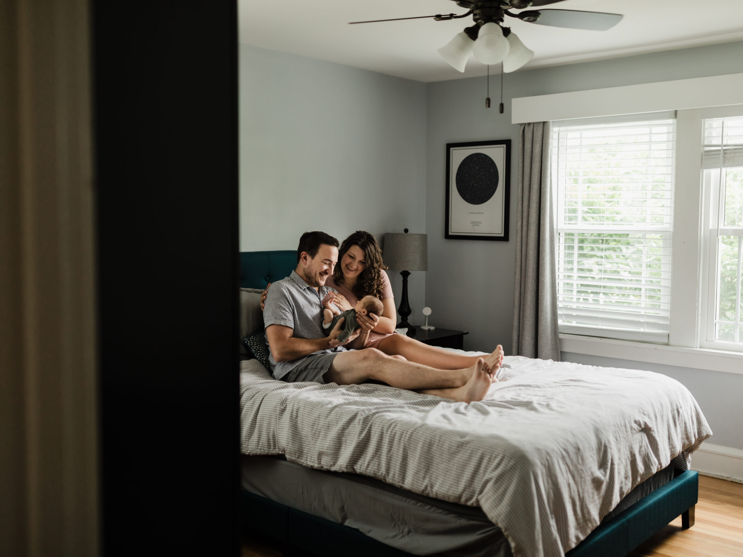 mom and dad holding newborn baby boy in master bedroom Cleveland Clinic Lactation Consultant